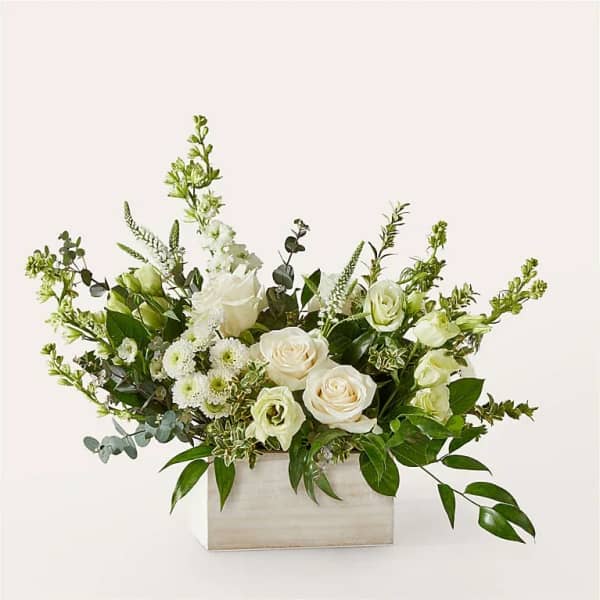 White roses and small white blooms in a rectangular wooden box