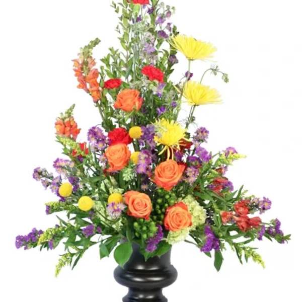 Tall mixed flower arrangement in a black urn vase