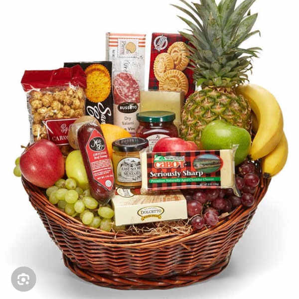 Fruit and snack gift basket in a wicker basket with a pineapple on top