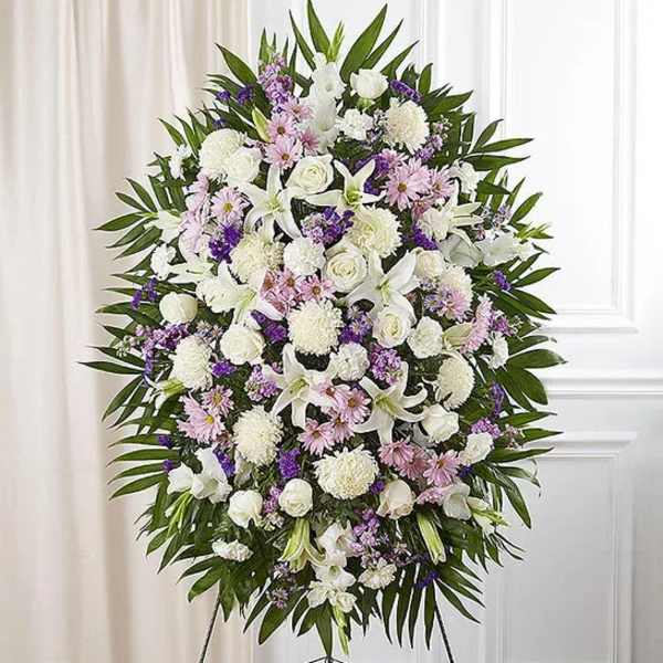 Large white and lavender funeral spray on an easel