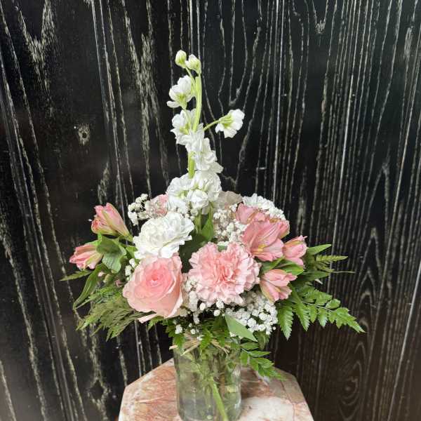Pink and white floral arrangement in a glass vase