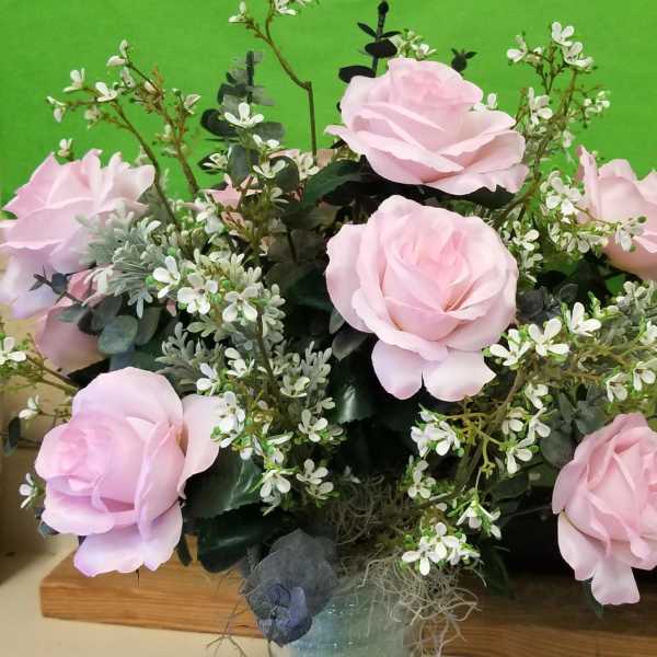 Arrangement of pale pink roses with small white blossoms