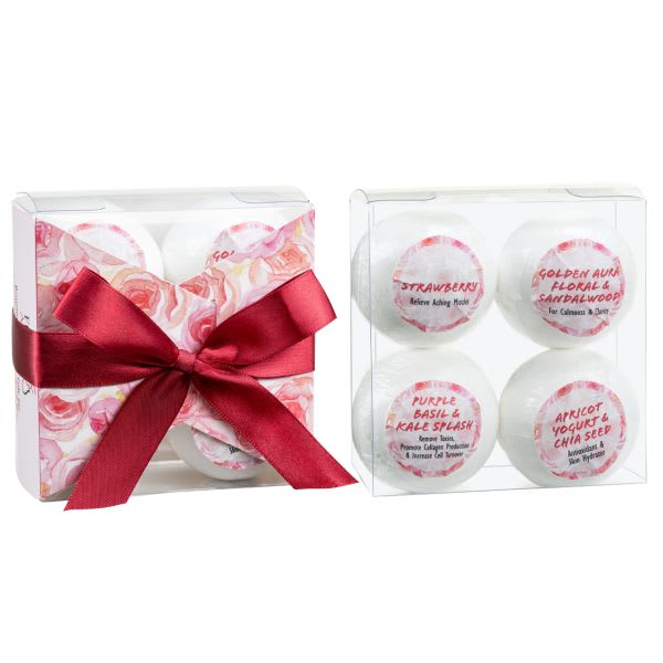 Gift set of four scented bath products in clear boxes with a red ribbon