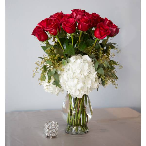 Red roses and white hydrangeas in a clear glass vase