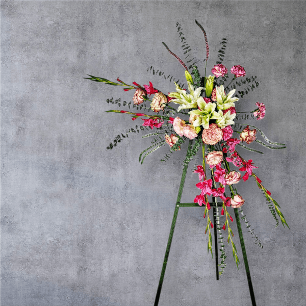 Tall floral arrangement with pink and white blooms on a stand