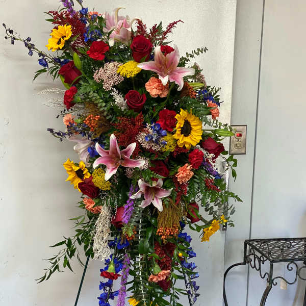 Tall standing floral spray with roses, lilies, and sunflowers