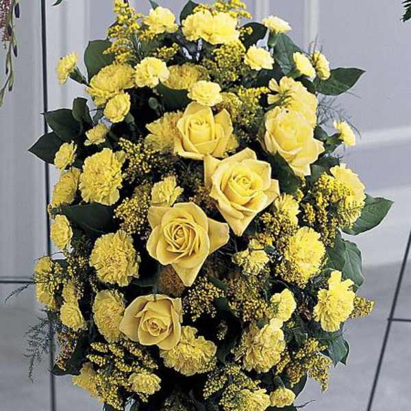 Yellow roses and carnations in a standing floral spray
