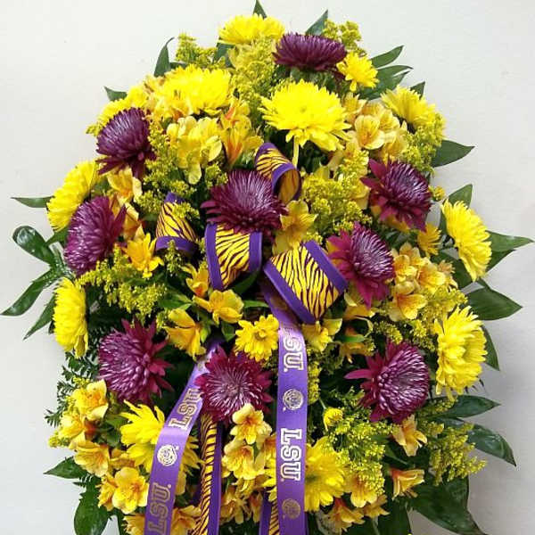 Large yellow and purple floral standing spray with LSU ribbons