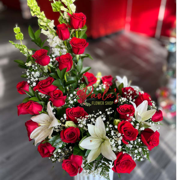 Red roses and white lilies in a tall white vase