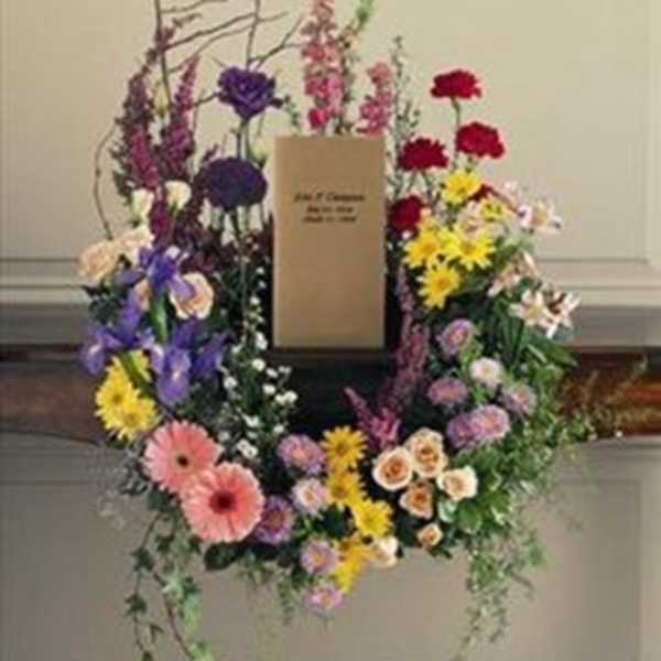 Colorful floral wreath with a central card on a stand