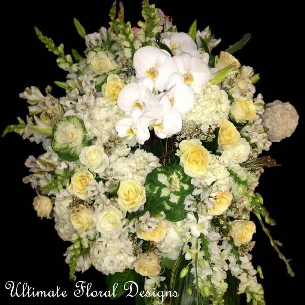 White and pale yellow floral arrangement with orchids and roses