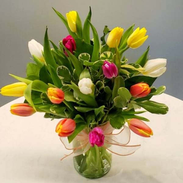 Bouquet of multicolored tulips in a clear glass vase
