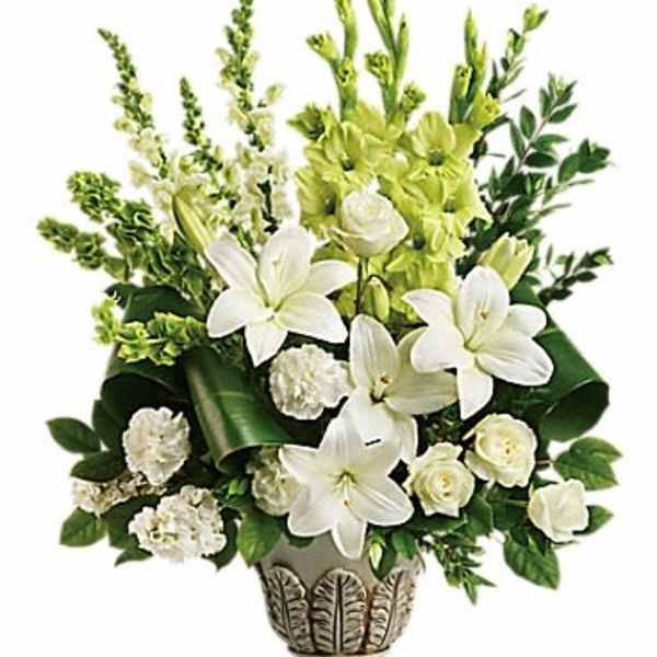 White lilies and green flowers arranged in a decorative vase