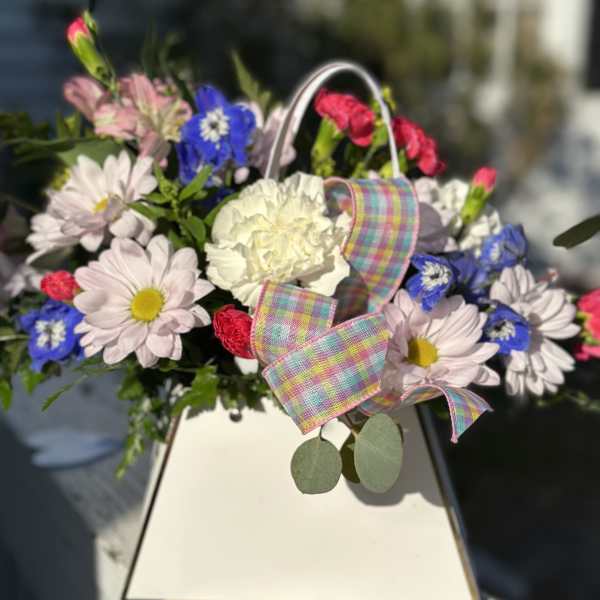 Mixed bouquet with daisies, carnations, and a plaid ribbon in a white box