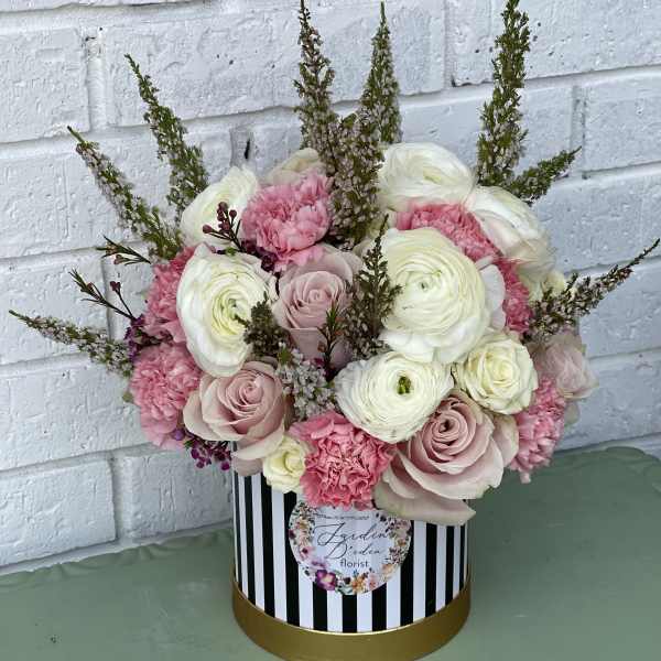 Pink and white bouquet in a striped round box
