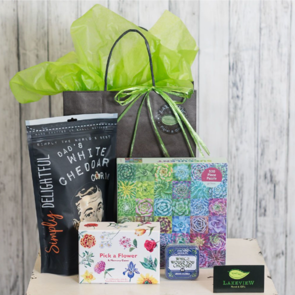 Gift bag with tissue paper and assorted flower-themed games and puzzles