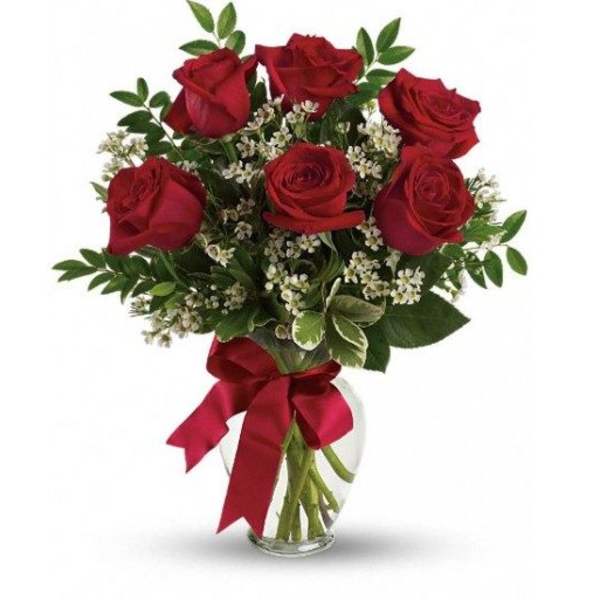 Red roses in a glass vase with a red ribbon