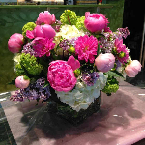 Pink and white floral arrangement in a square glass vase