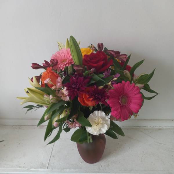 Mixed bouquet in a vase with pink, red, orange, and white flowers