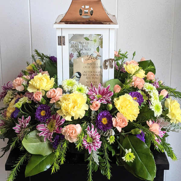 Sympathy lantern surrounded by pastel flowers
