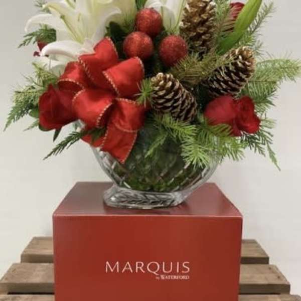 Holiday arrangement of white lilies and red roses in a glass vase
