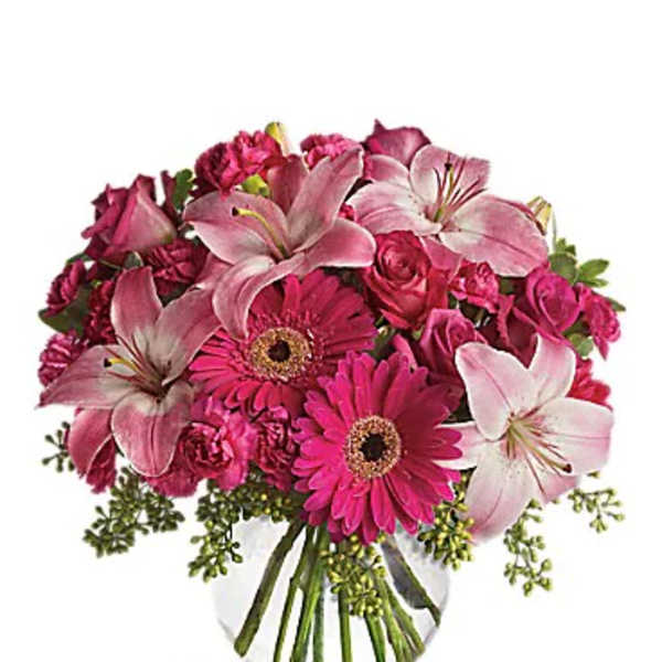 Pink lilies and gerbera daisies in a clear glass vase