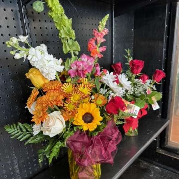 Mixed bouquet with sunflowers, roses, and snapdragons in a vase