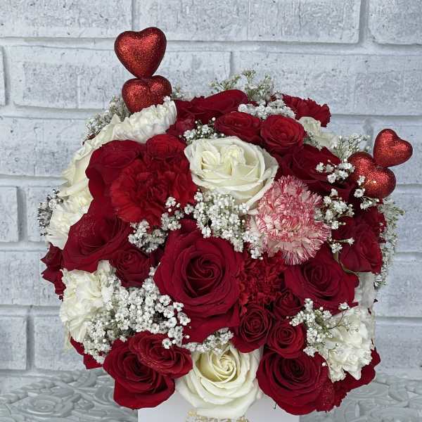 Red and white rose bouquet with glittery heart picks in a white box