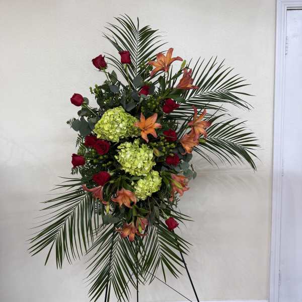 Standing floral spray with red roses, orange lilies, and green hydrangeas
