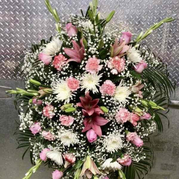 Pink and white funeral spray with lilies, carnations, and chrysanthemums