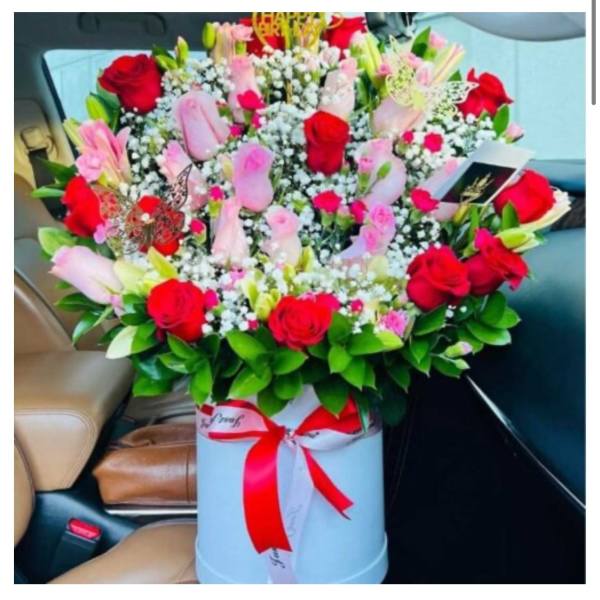 Large bouquet of red and pink roses in a white box with a red ribbon