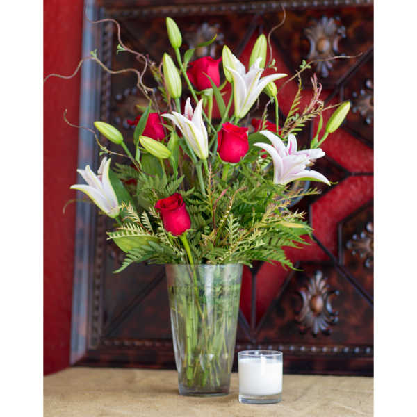 Red roses and white lilies in a clear glass vase