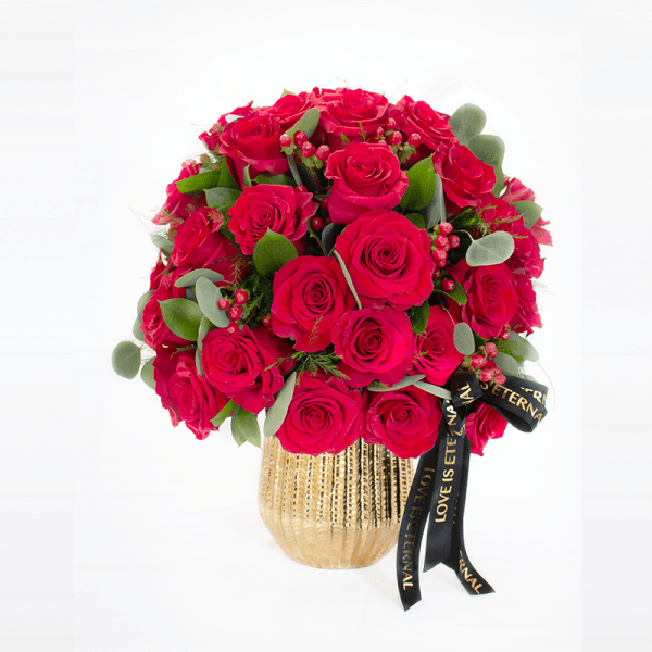 Bouquet of red roses in a gold vase with a black ribbon