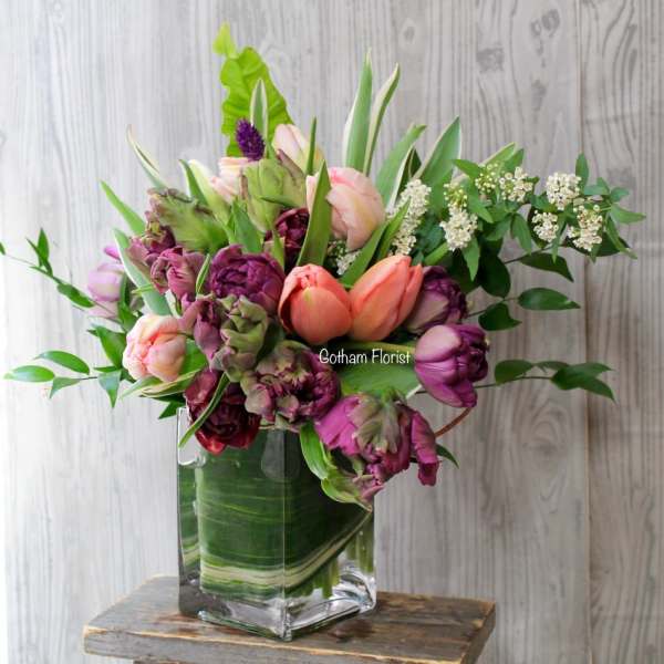 Bouquet of tulips and purple blooms in a clear glass vase