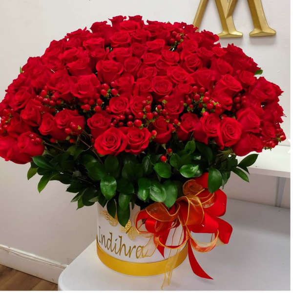 Large bouquet of red roses in a white hatbox with a red ribbon