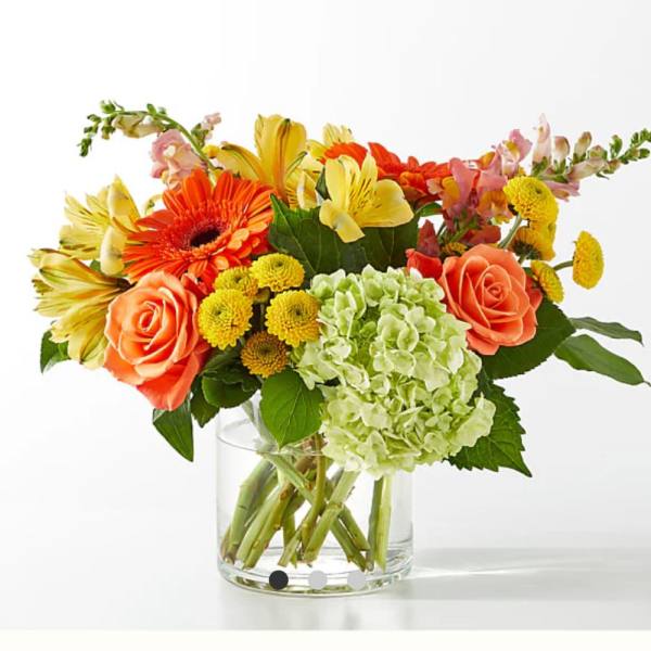 Colorful bouquet in a clear glass vase with roses, gerbera daisies, and hydrangea