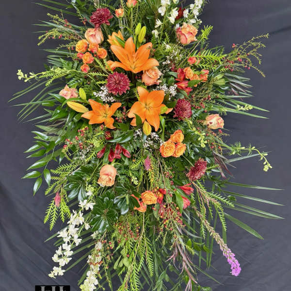 Tall floral spray with orange lilies, roses, and white blossoms