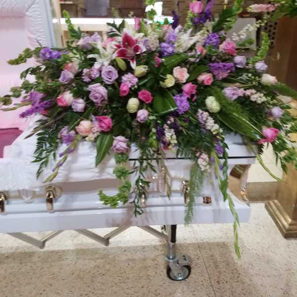 Large casket spray with pink, purple, and white flowers