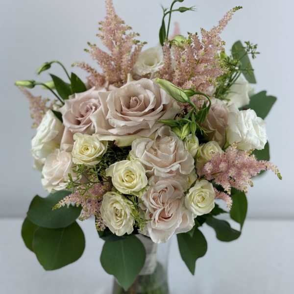 Bouquet of pale roses and pink astilbe in a glass vase