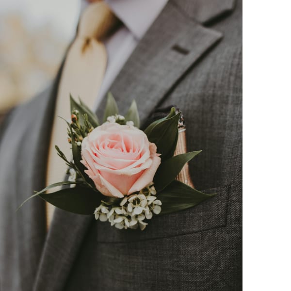 Pink rose boutonniere on a gray suit lapel
