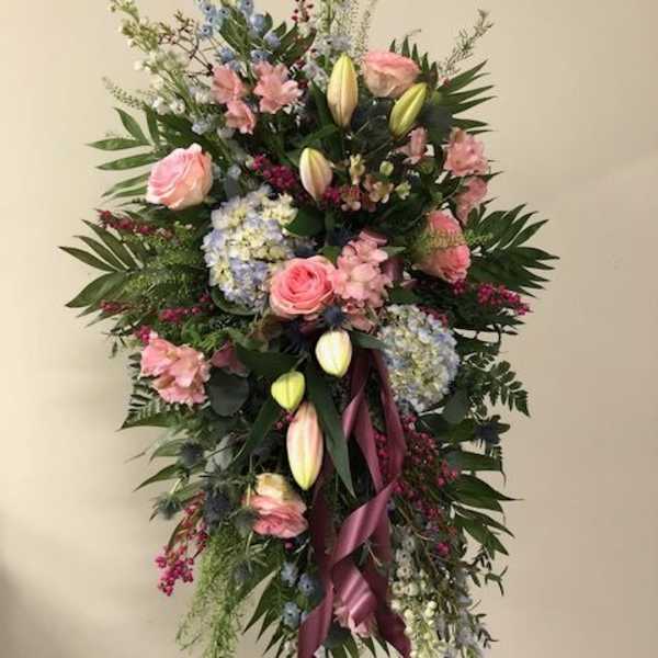 Tall standing floral spray with pink roses, lilies, and blue hydrangeas