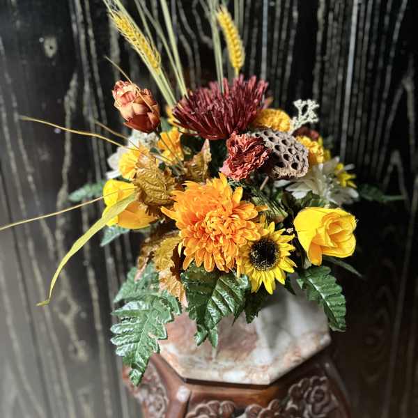 Autumn floral arrangement with yellow and orange blooms in a vase