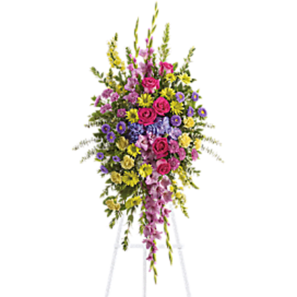 Tall standing floral spray on a white easel with pink, yellow, and purple flowers.
