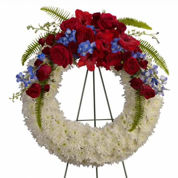 Red and white floral wreath on a black stand