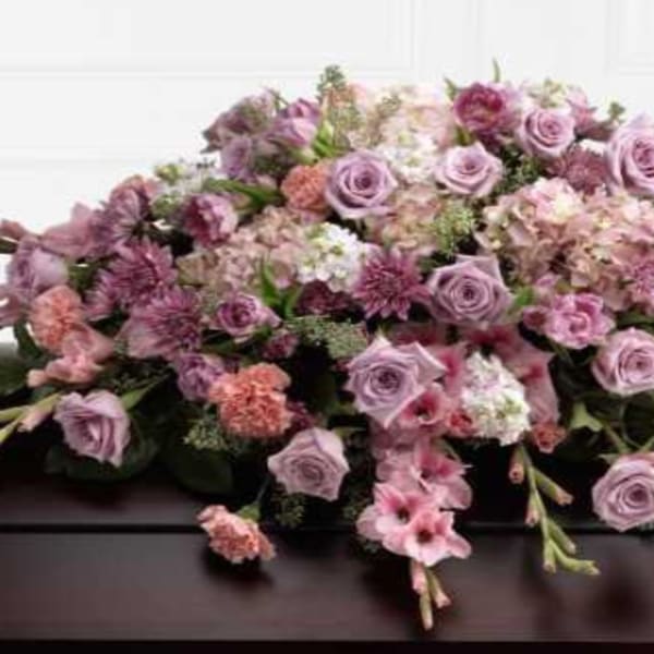 Lavender and pink floral casket spray with roses and carnations