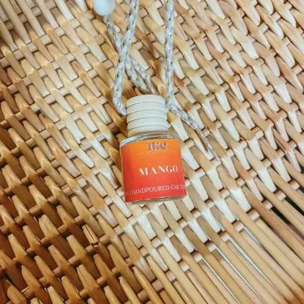 Small hanging bottle labeled mango on a woven background