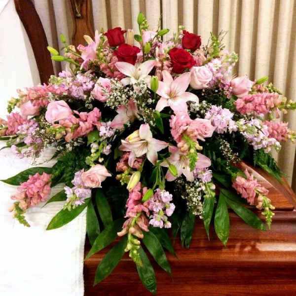 Large pink and white floral casket spray with roses and lilies