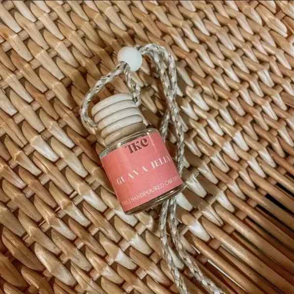 Small glass hanging bottle with a pink label and braided cord