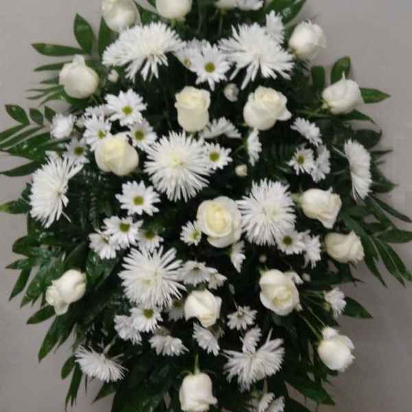 White floral funeral spray with roses and daisy-like blooms