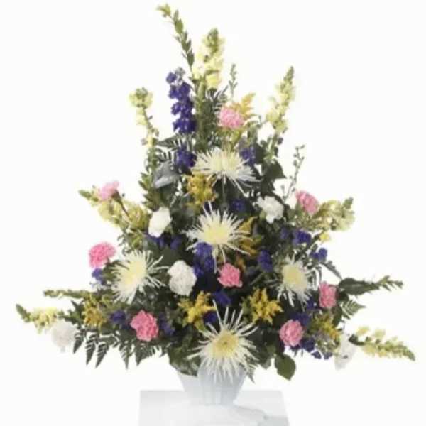 Tall mixed flower arrangement in a white vase